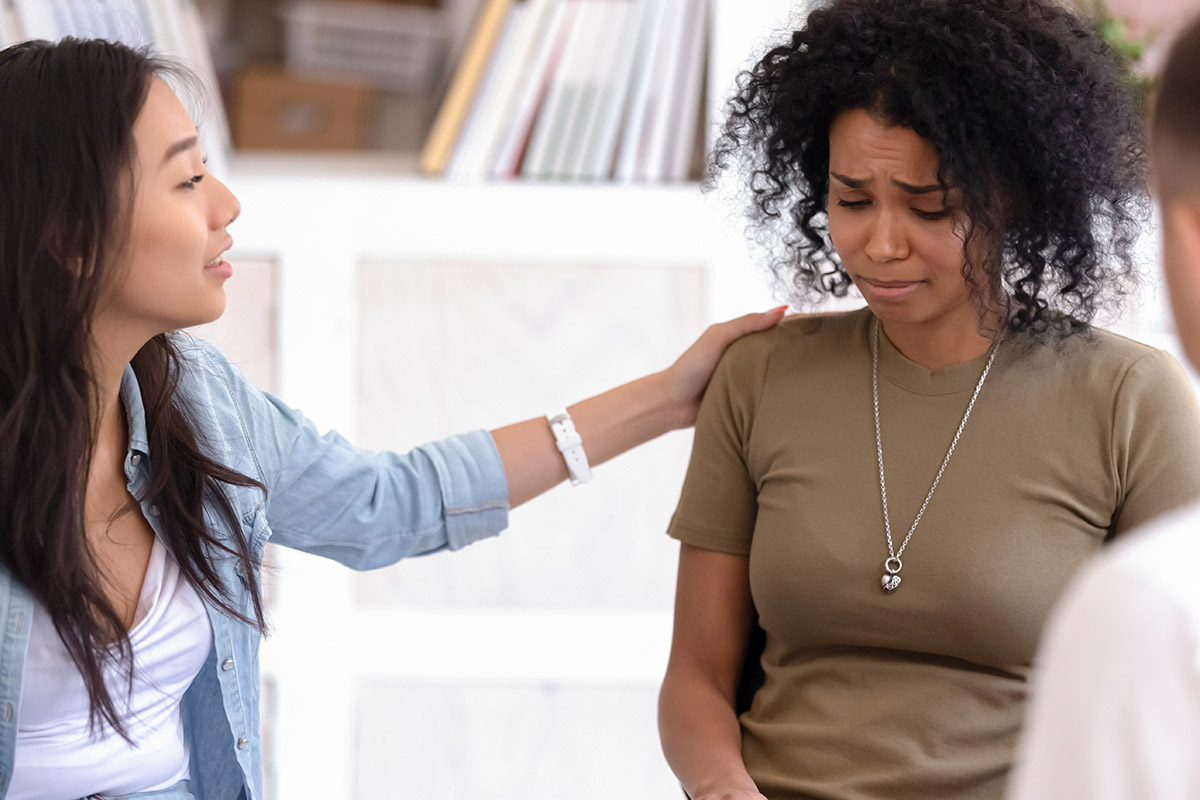 woman comforting crying woman finding help in residential treatment centers