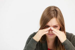 woman sits with hands on her head needing a percocet addiction treatment center