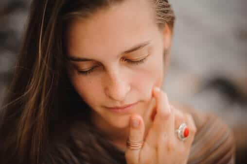 woman touching face with her eyes closed thinking about the dangers of poly substance abuse