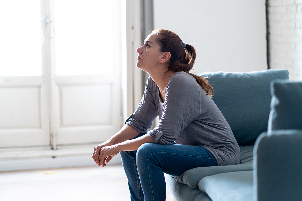 woman sits on couch and looks up at the ceiling while overcoming social anxiety disorder