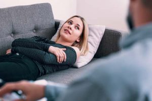 a woman laying down on a couch at a vyanse addiction treatment center