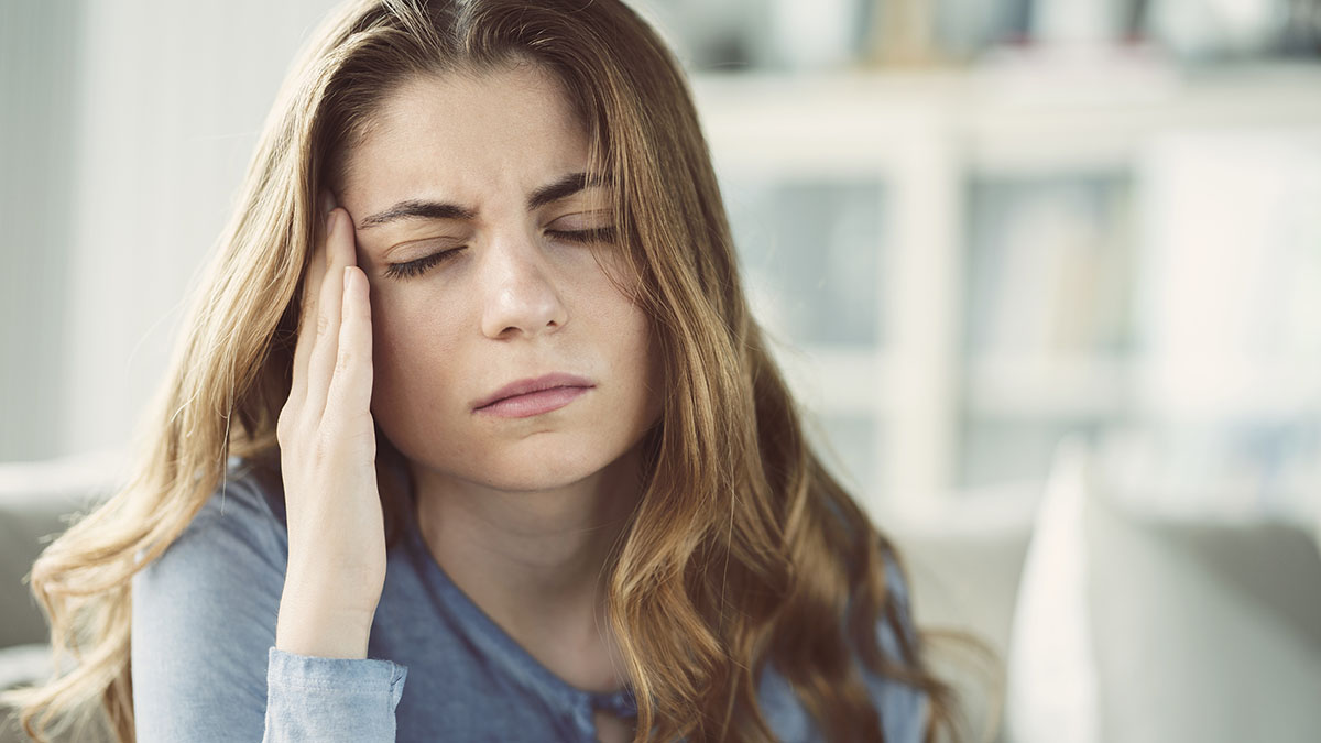 consequences of drug abuse, woman rubbing her aching head