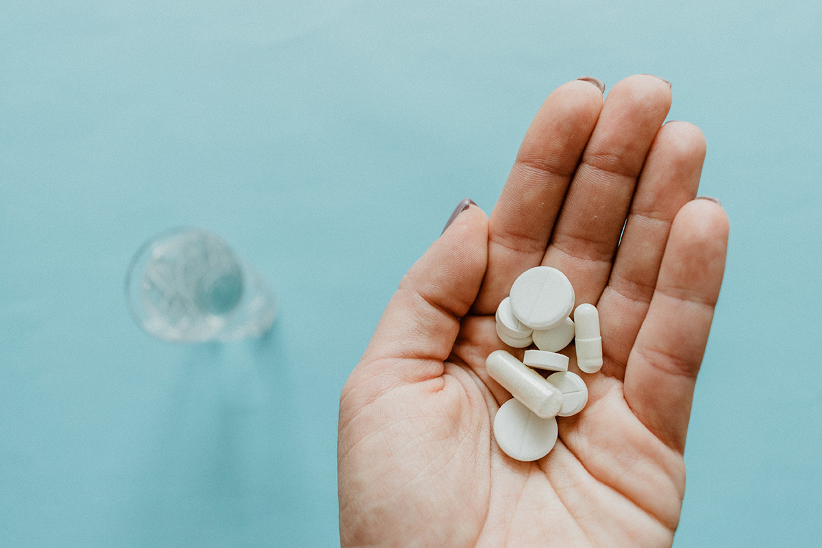 woman holding pills in hand as she struggles with prescription drug addiction