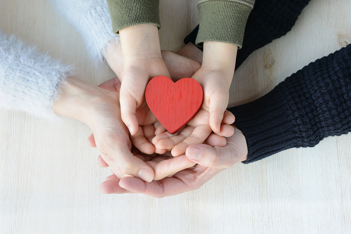 family holding a heart after learning the benefits of a family therapy program