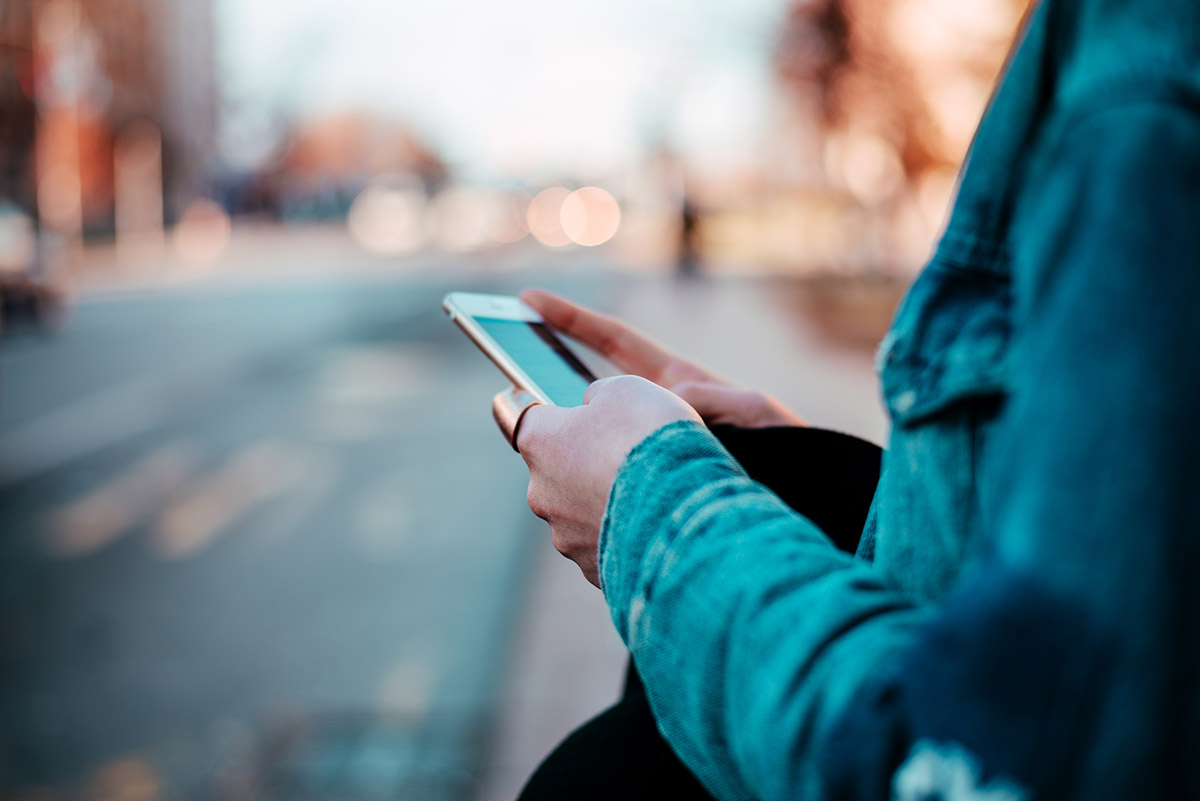 individual on their phone and unsure about the connection between social media and alcohol consumption